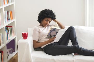 Woman reading a book on the couch 